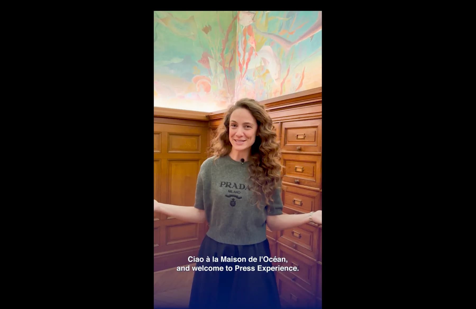 Une participante à la Press Experience, filmée devant les boiseries d’un salon peint
