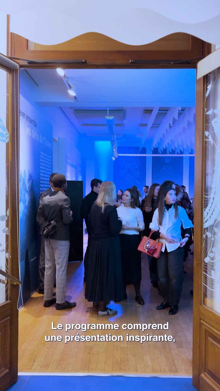 Une réception dans un espace d'exposition de la Maison de l'Océan, éclairé en bleu