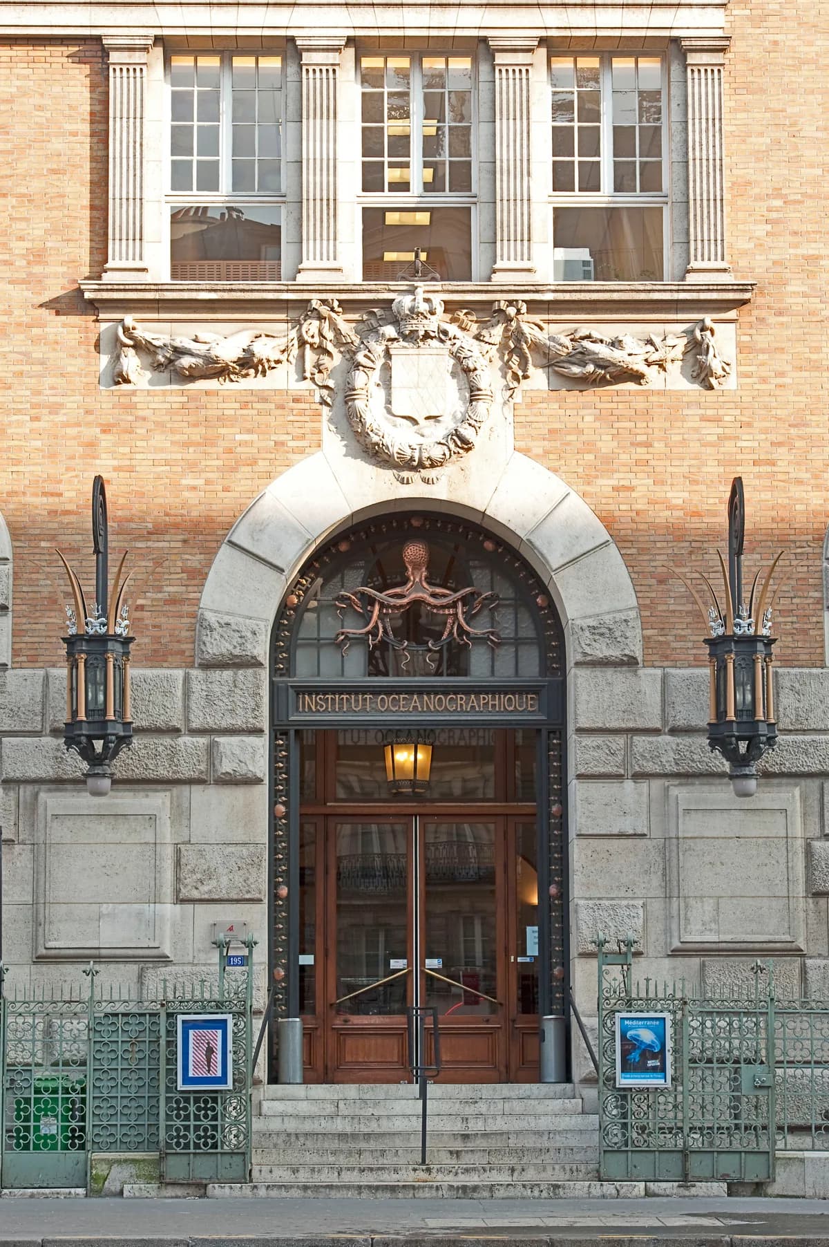 Le porche d’entrée de l’Institut océanographique, surmonté d’une pieuvre de bronze et encadré de deux torchères en fer forgé.