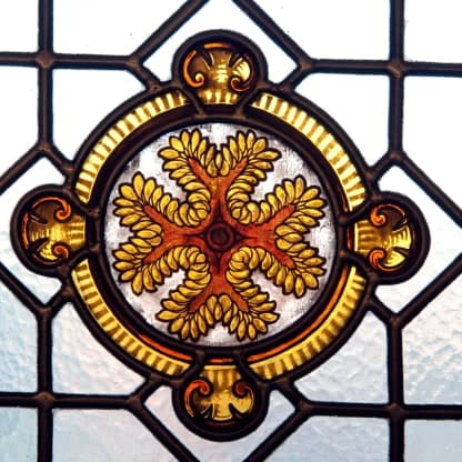 Détail d'un vitrail de la Maison de l'Océan : une rosace de feuillages dorés cernée de plomb